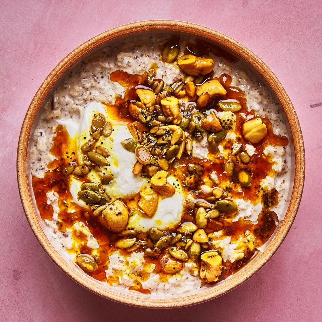 Overnight oats topped with a mix of turmericstained nuts and seeds toasted in ghee.